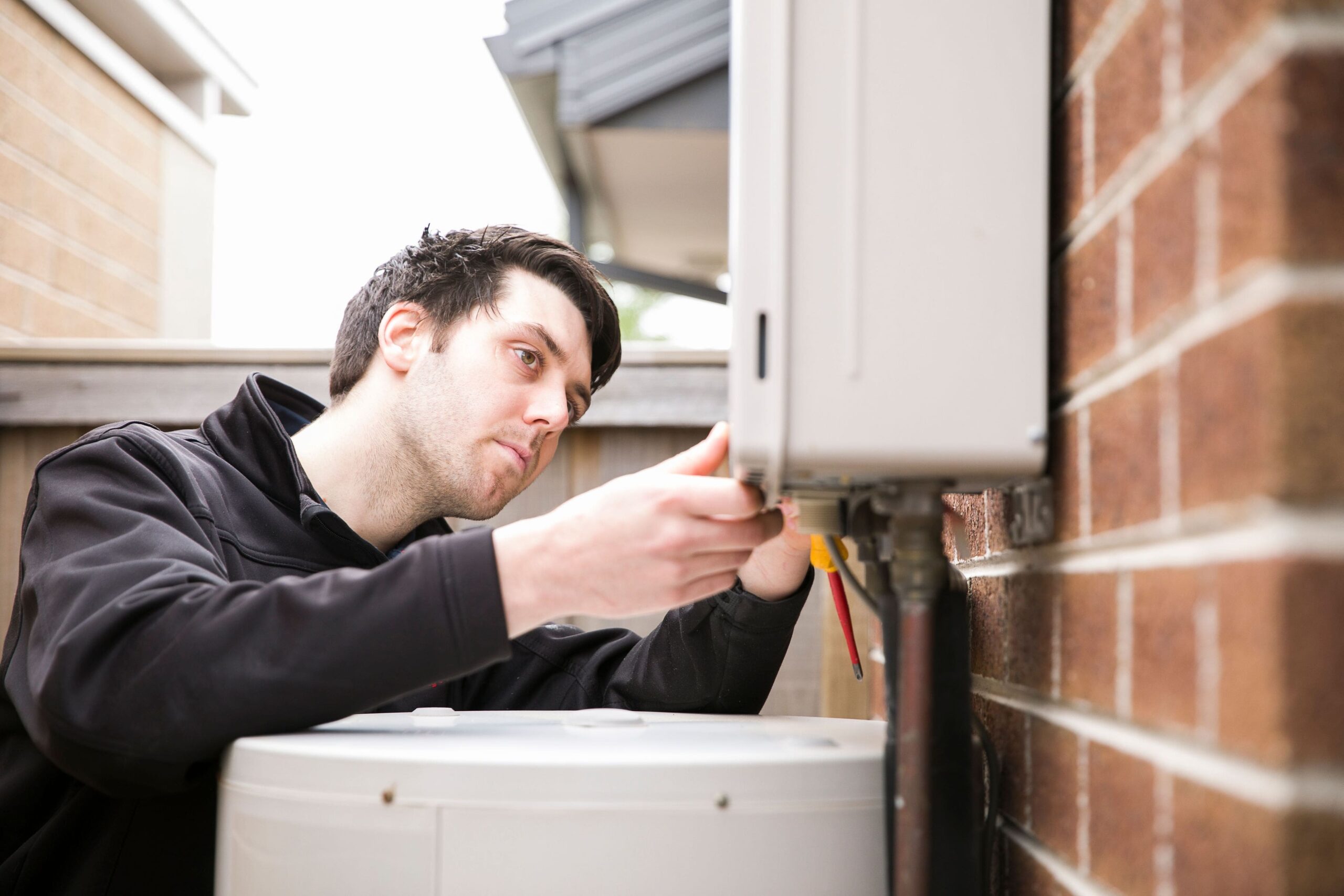 Electrician repairing hot water unit