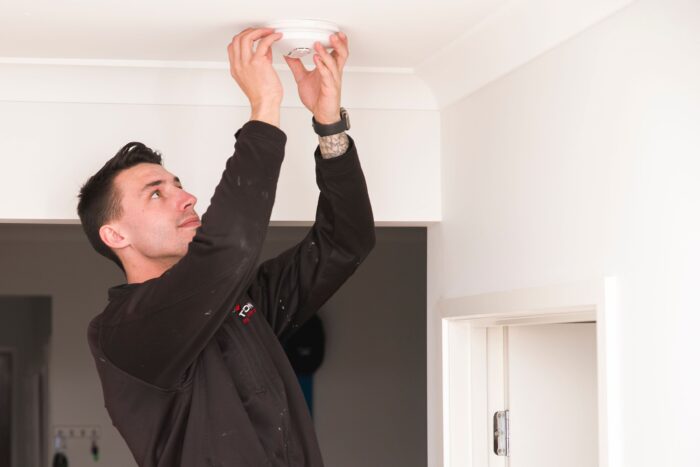 Jarrod the electrician installing a smoke alarm