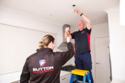 Qualified electrician and apprentice electrician installing down lights