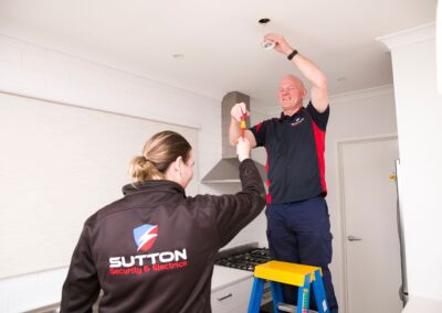 Qualified electrician and apprentice electrician installing down lights
