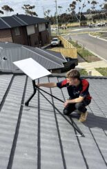 Electrician installing a starlink on the roof of a home